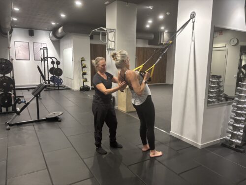 Personlig träning med PT som coachar individen på gym